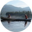 Two scouts paddle a canoe.